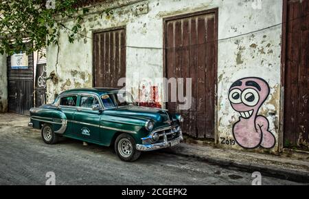 Havana, Kuba, Juli 2019, Green American 50er `s-60er `s Chevrolet Auto geparkt von einem Graffiti im ältesten Teil der Stadt Stockfoto